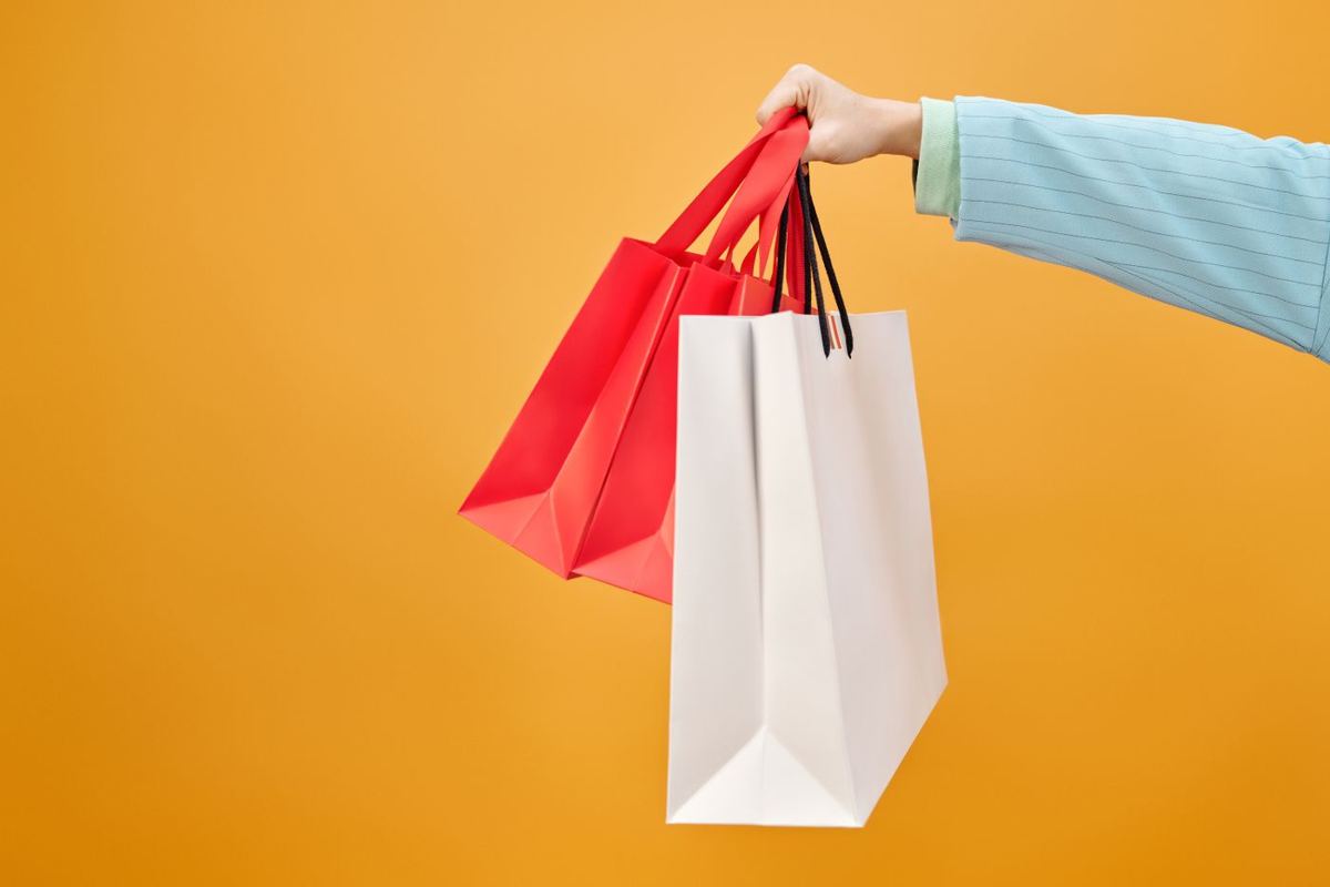 Mão segurando sacolas de compras
