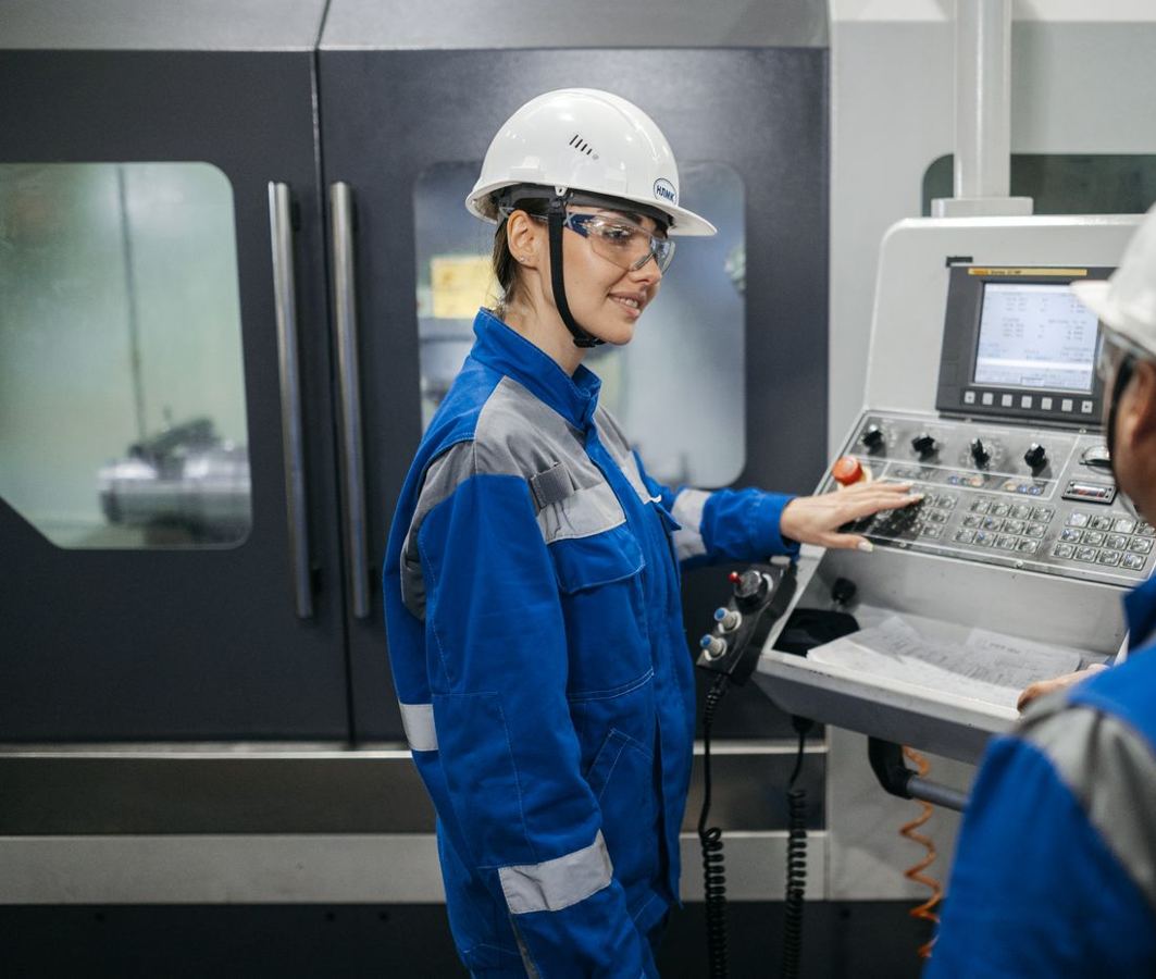 Profissionais de uniforme e capacete em um ambiente industrial
